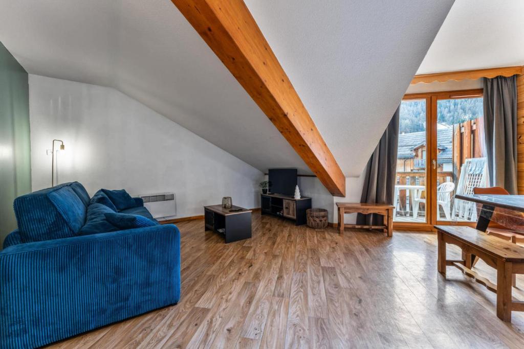 un salon avec un canapé bleu et une table dans l'établissement Résidence Les Hauts De Preclaux - Appartement 6 personnes au coeur des Orres 1800 MAE-5351, aux Orres