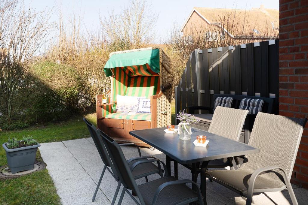 a patio with a table and chairs and a fence at Relax in Burg auf Fehmarn