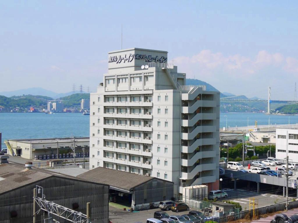 a white building with a sign on top of it at Hotel Route-Inn Mojiko in Kitakyushu