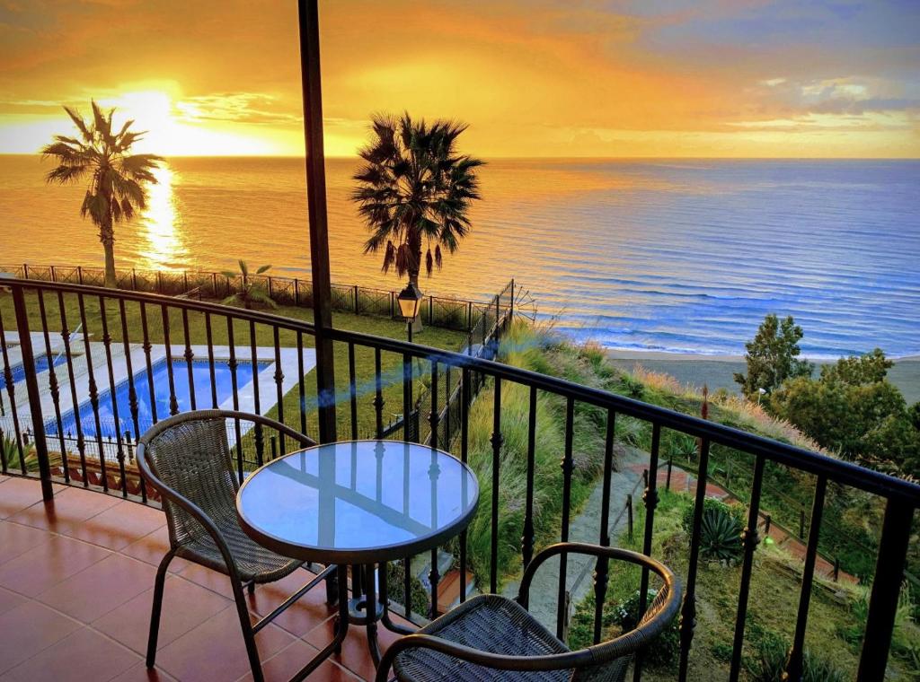 balkon ze stołem i krzesłami oraz oceanem w obiekcie Orange On the Beach - Balcon de Benalmadena w mieście Benalmádena