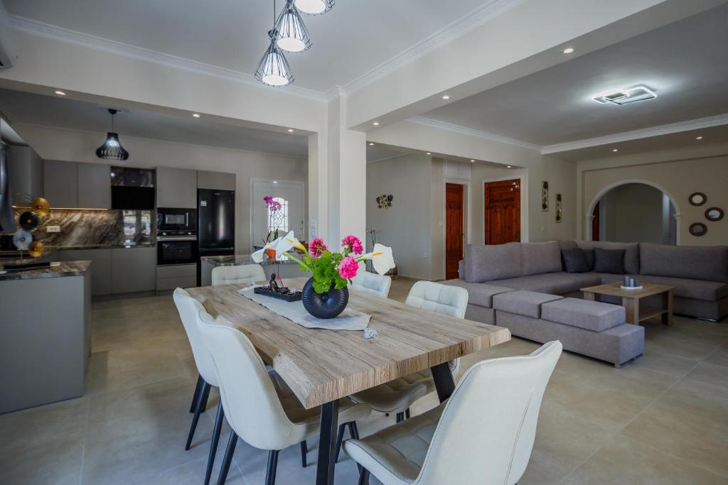 a kitchen and living room with a wooden table and chairs at Villa Kotetsi in Laganas