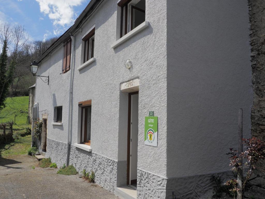 a white building with a sign on the side of it at La Maison d'Anna in Saint-Lary
