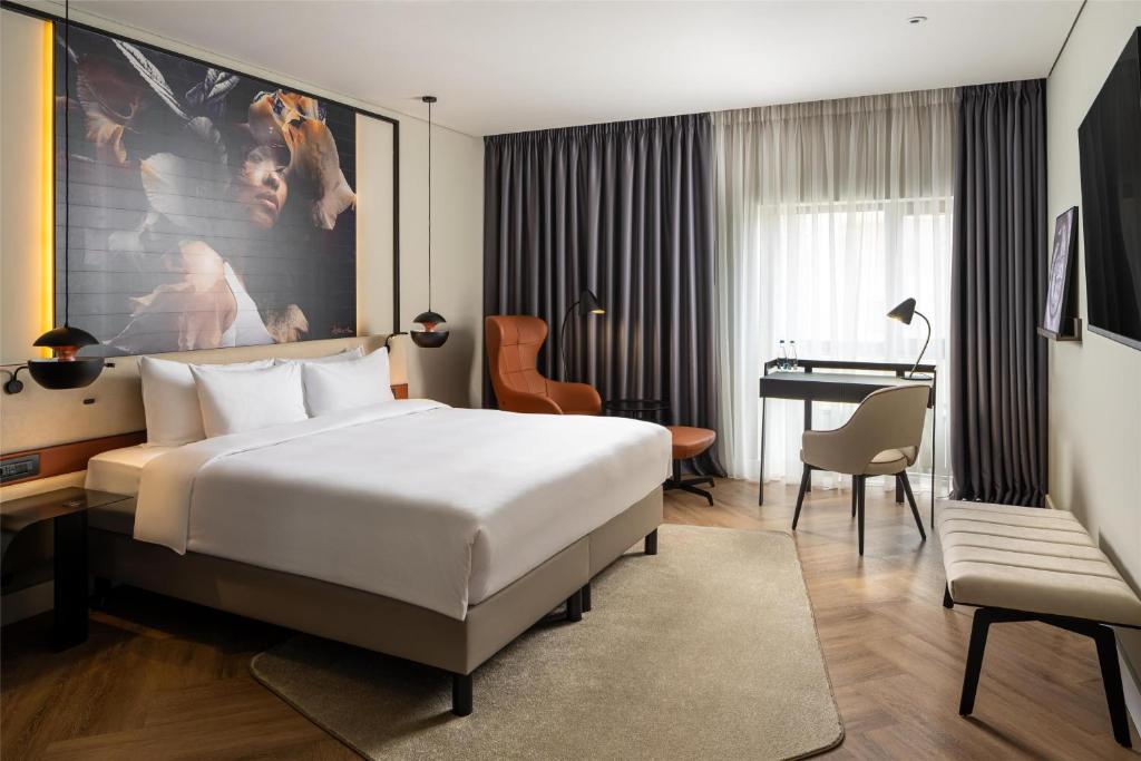 a hotel room with a large bed and a desk at Radisson Blu Hotel Bucharest in Bucharest