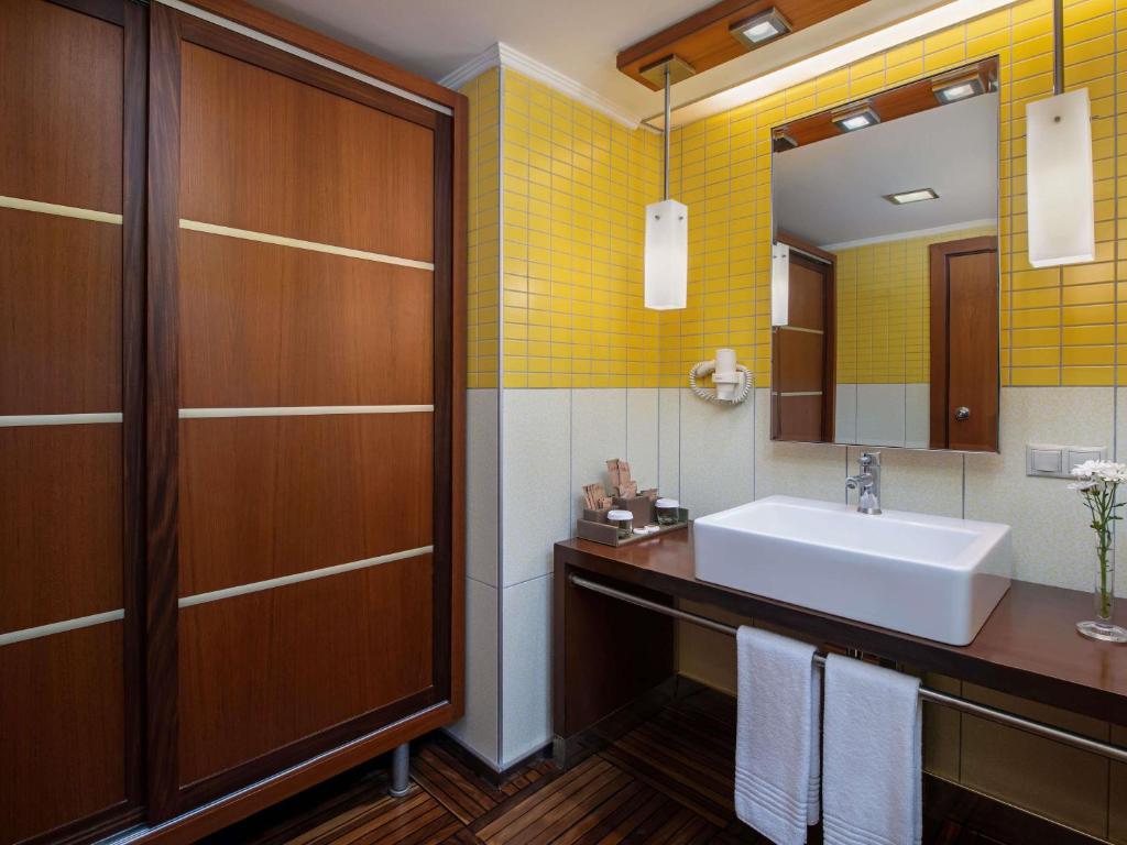 a bathroom with a sink and a mirror at Rixos Sungate - The Land of Legends Access in Beldibi