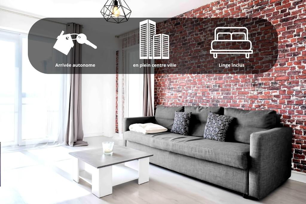 un salon avec un canapé et un mur de briques dans l'établissement Pearl of Amiens center, Train station, Parking, à Amiens