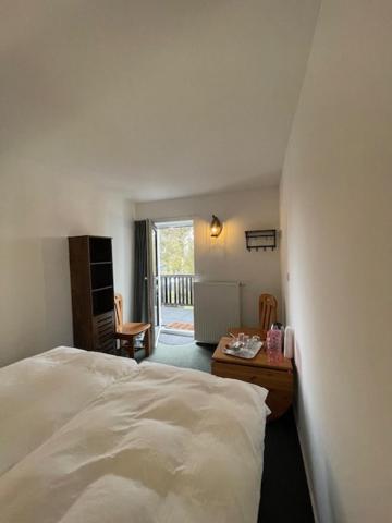 a bedroom with a bed and a desk and a kitchen at Luxushütte Welgelegen in Bestwig