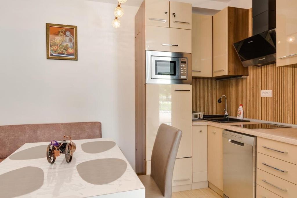 Una pequeña cocina con una mesa con una bicicleta de juguete encima. en Apartman Dolly Vrnjacka banja, en Vrnjačka Banja