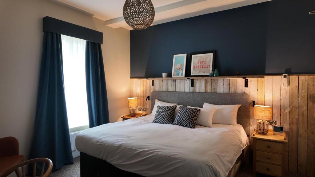 a bedroom with a large bed with a blue wall at Downs Hotel in Stanmer