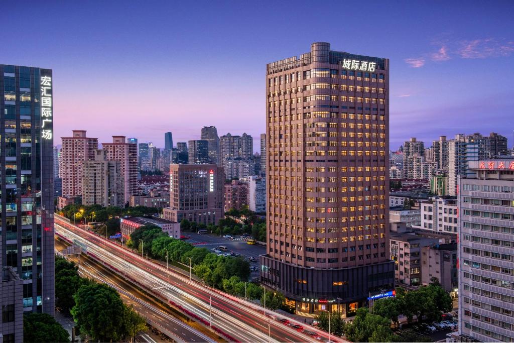 a tall building in the middle of a city at Intercity Hotel Shanghai City Center - Free Mini Bar in Shanghai