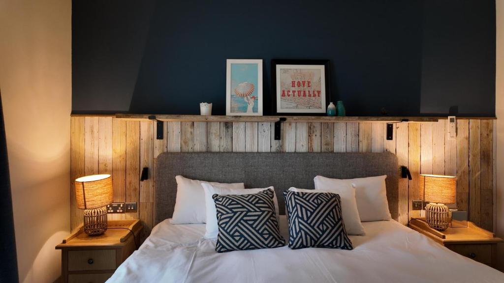 a bedroom with a white bed with two pillows at Downs Hotel in Stanmer