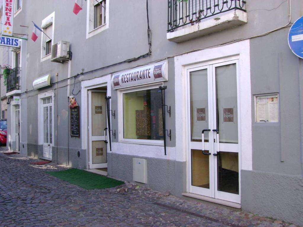 a building with doors and windows on a street at Residencia Paris in Coimbra