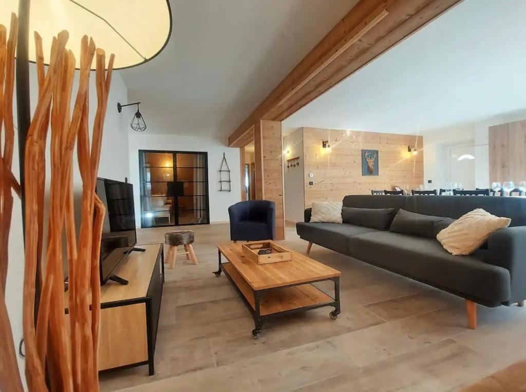 un salon avec un canapé et une table dans l'établissement Cozy & modern apartment, à Samoëns