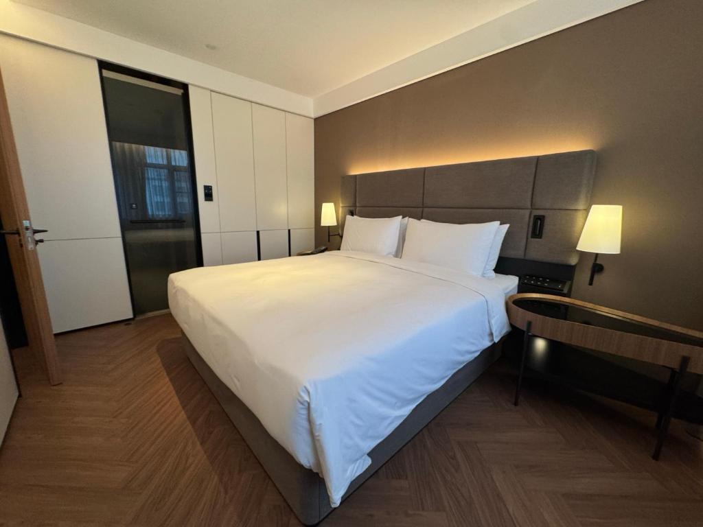 a large white bed in a hotel room at Intercity Hotel Shanghai City Center - Free Mini Bar in Shanghai