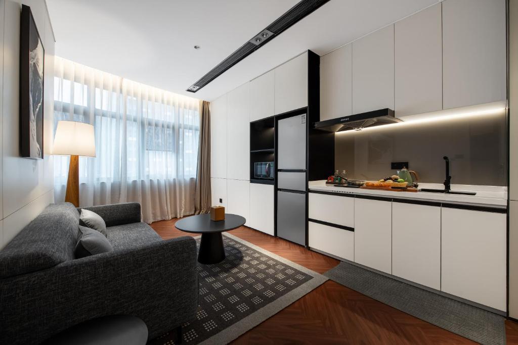 a living room with a couch and a kitchen at Intercity Hotel Shanghai City Center - Free Mini Bar in Shanghai