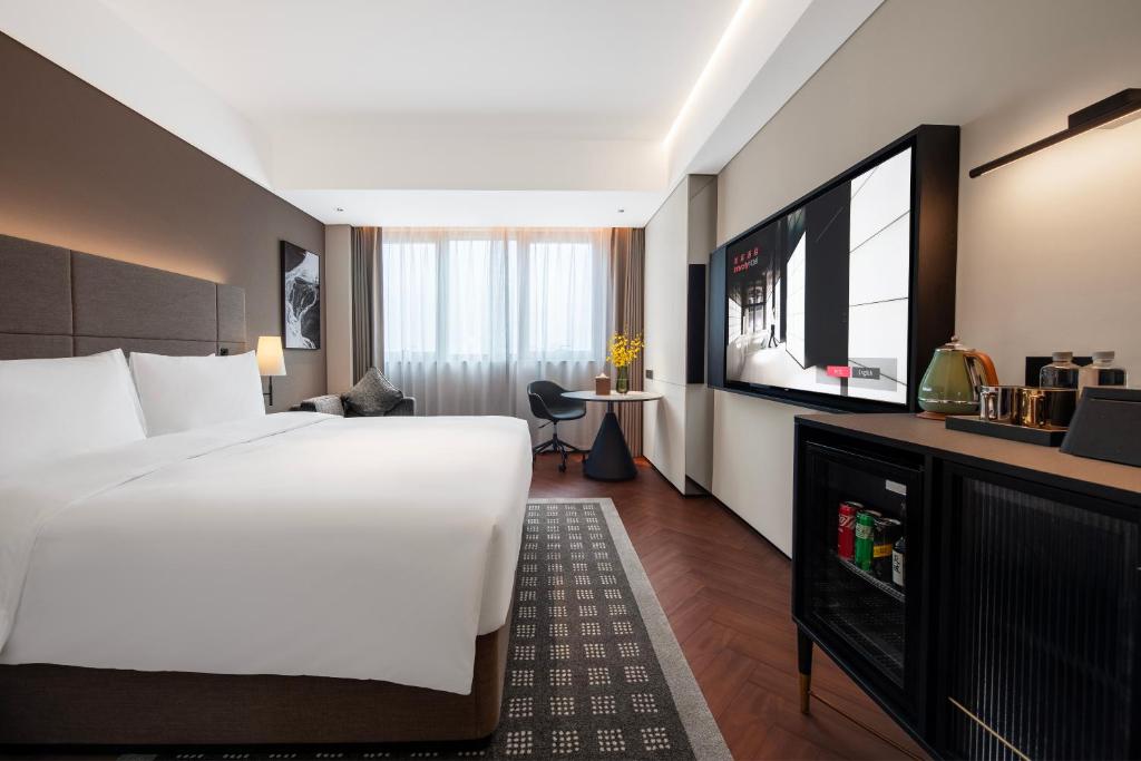 a hotel room with a large bed and a television at Intercity Hotel Shanghai City Center - Free Mini Bar in Shanghai