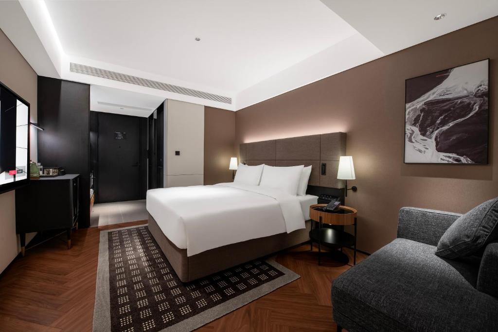 a hotel room with a bed and a couch at Intercity Hotel Shanghai City Center - Free Mini Bar in Shanghai