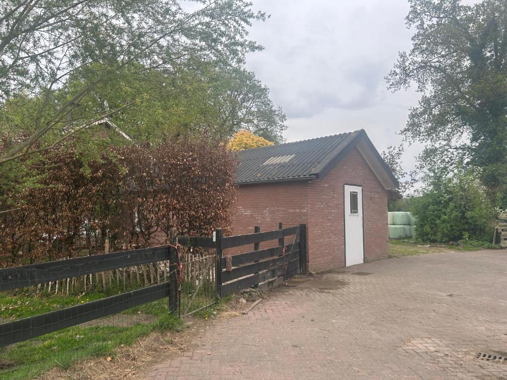 a red brick building with a gate and a fence at Zonneoord in Ede
