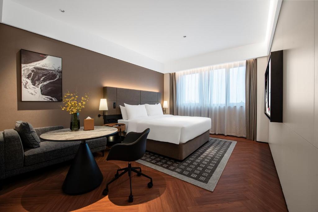 a hotel room with a bed and a couch at Intercity Hotel Shanghai City Center - Free Mini Bar in Shanghai