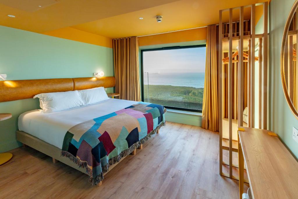 a bedroom with a bed and a large window at SeaSpace in Newquay