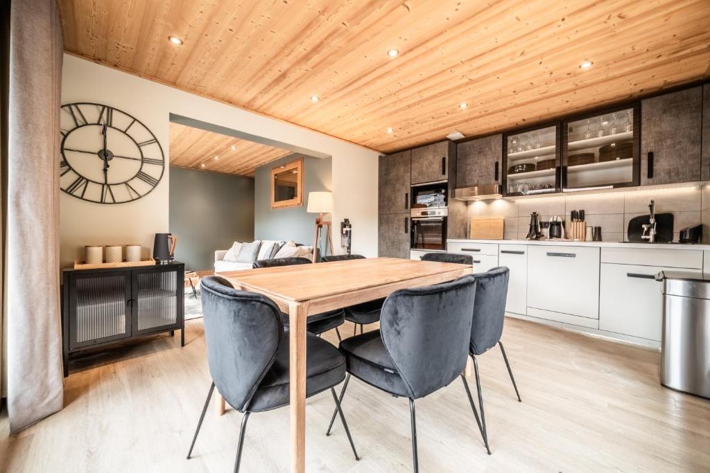a kitchen and dining room with a wooden table and chairs at Janin 3 Charmant appartement rénové avec 2 chambres et espace cabine in Morzine