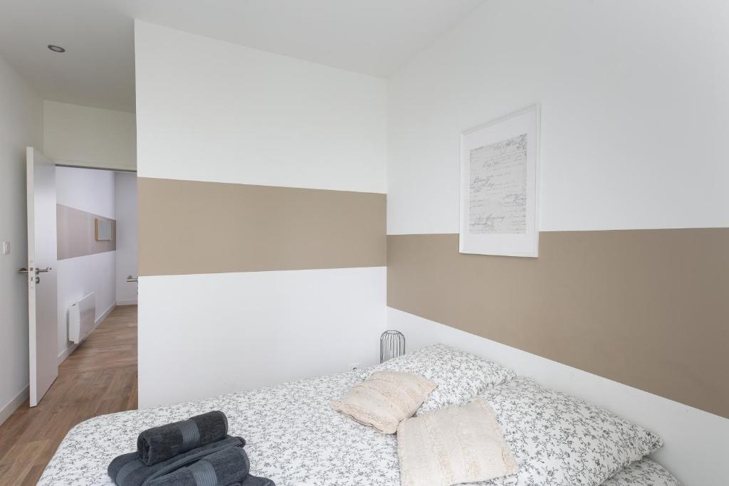 - une chambre avec des murs blancs et un lit dans l'établissement T2 L'Inflexible, à Brest