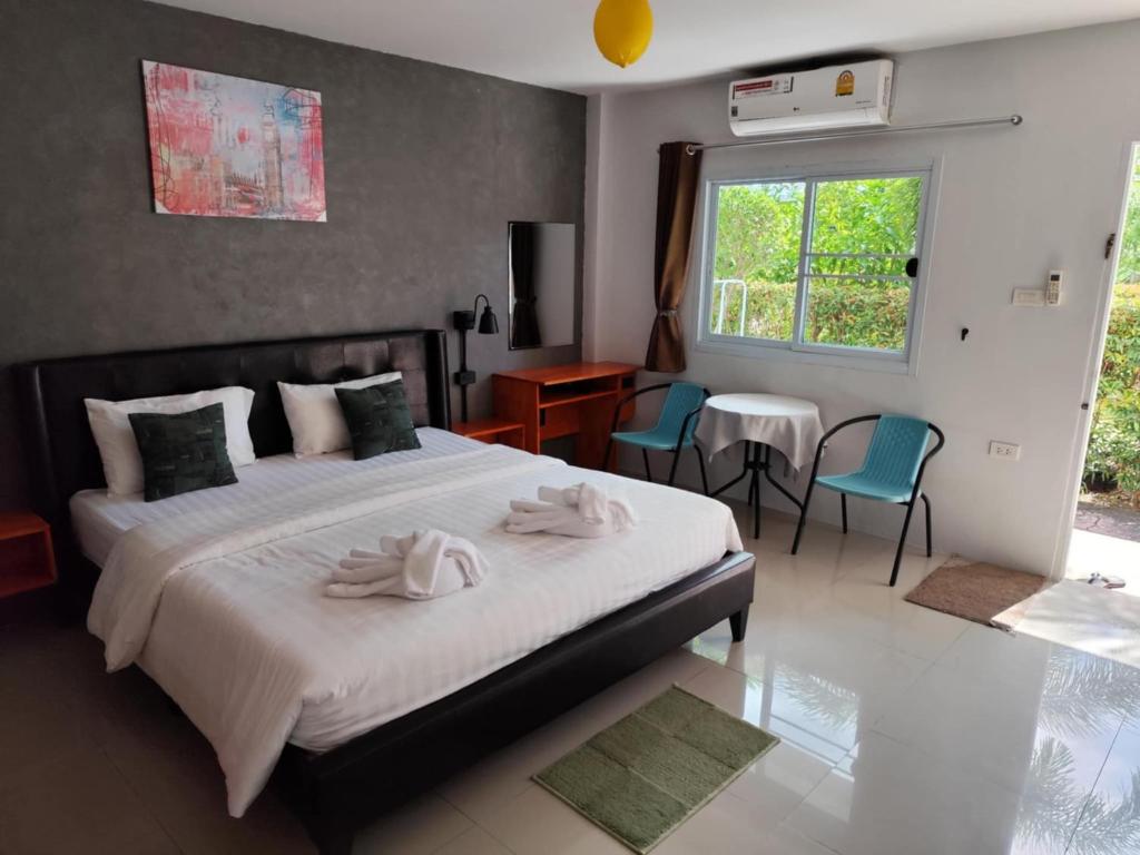 バンタオビーチにあるBangtao Mango Houseのベッドとタオル2枚のある寝室