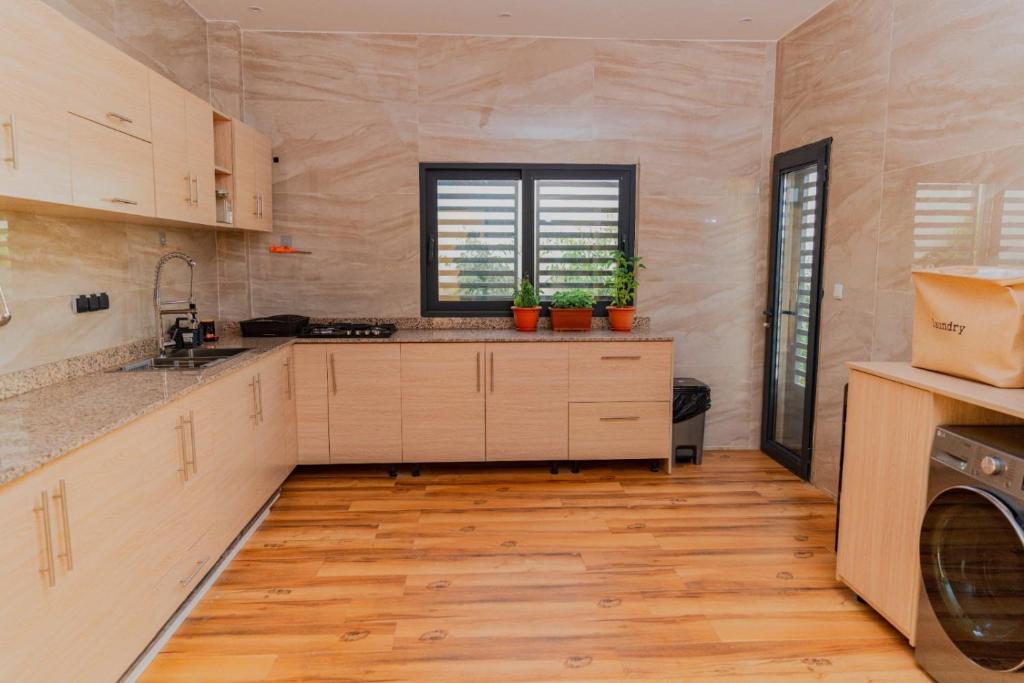 a large kitchen with a sink and a dishwasher at La villa Socé in Saly Portudal