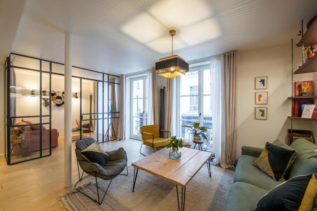 a living room with a couch and a table at Magnifique appartement central 3 chambres / 3 BDR in Paris