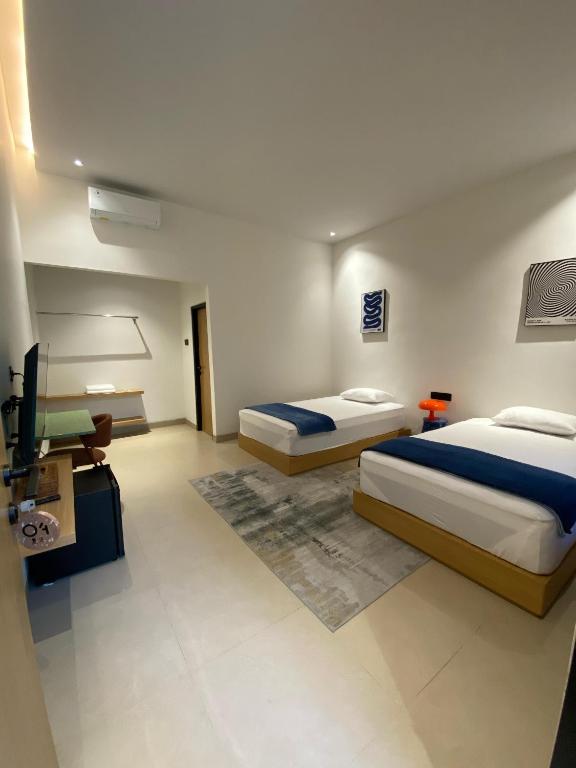 a hotel room with two beds and a television at Bale Seccha in Kuta Lombok