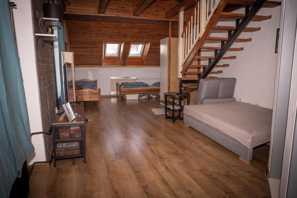 a living room with a bed and a staircase at Varady's large apartment with private parking in Košice