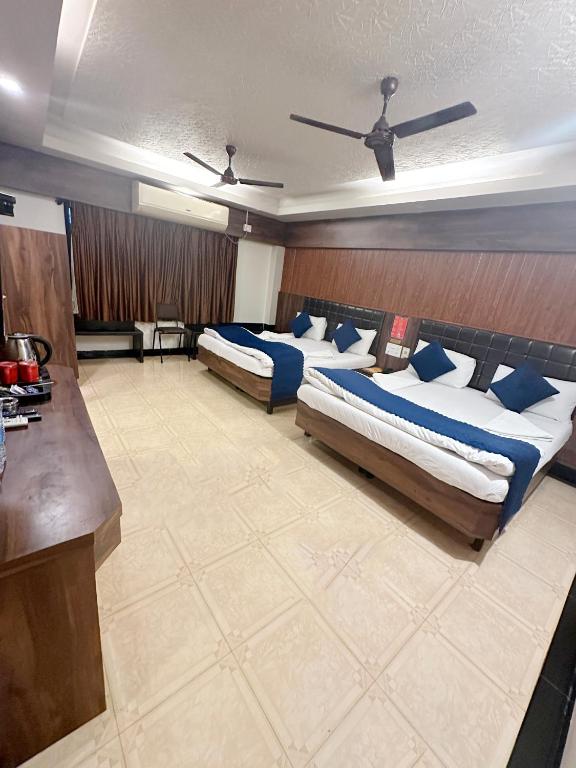 Postel nebo postele na pokoji v ubytování Saibaba International Hotel