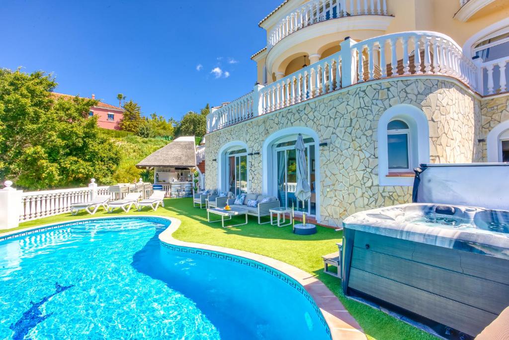a villa with a swimming pool in front of a house at Casa Darcey in Mijas
