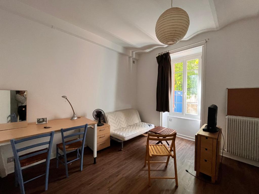 - un salon avec un bureau, une table et des chaises dans l'établissement Studio PMR proche du centre, à Clermont-Ferrand