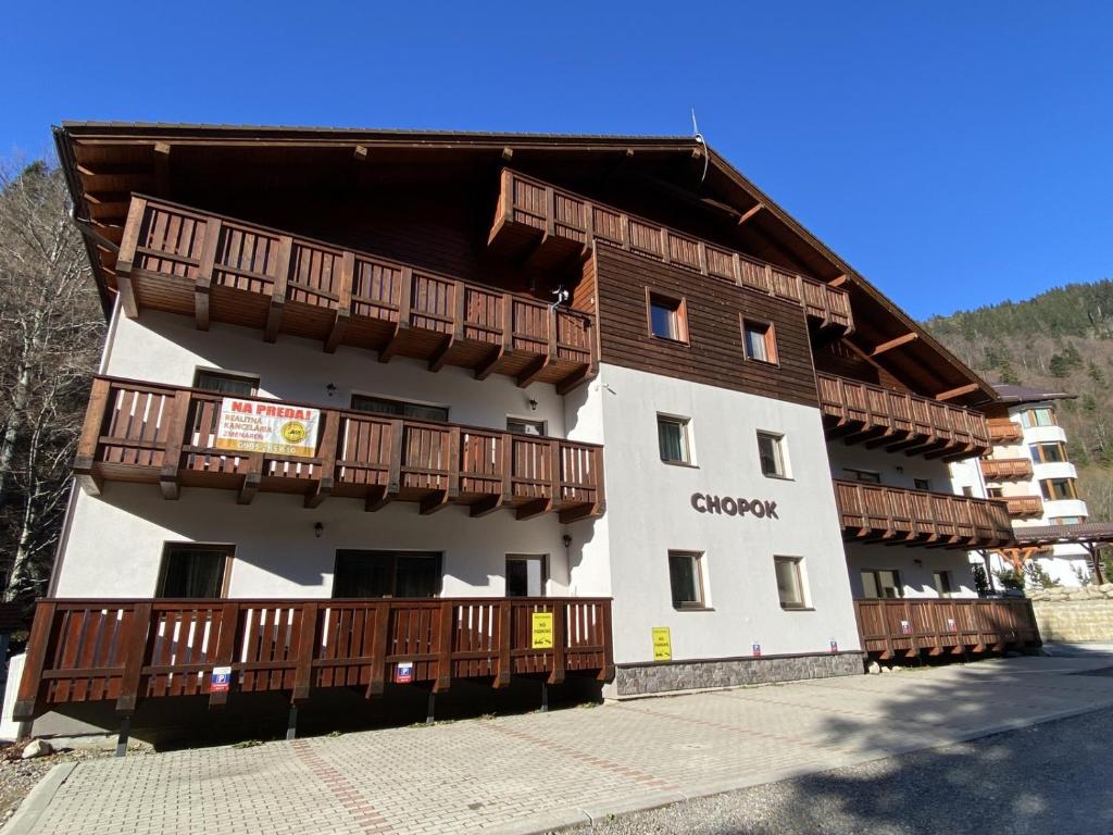 a building with wooden balconies on the side of it at Chopok Juh apartmán Yeti in Horná Lehota