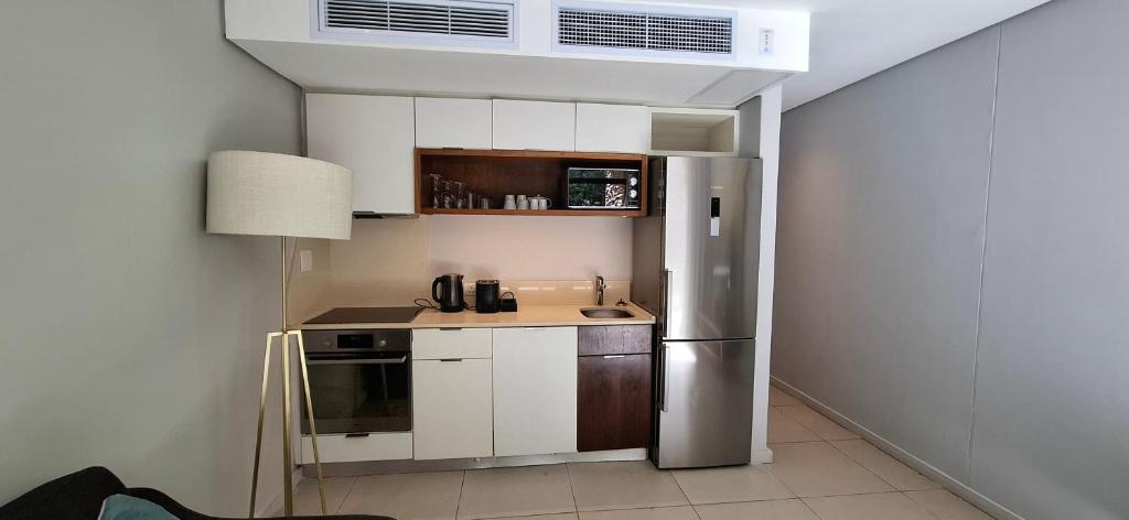 a small kitchen with a stainless steel refrigerator at Zimbali Suites 317 - 1 bedroom in Ballito