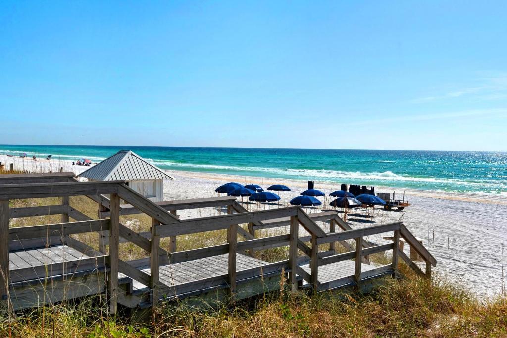 ein Strand mit einigen Liegen und Sonnenschirmen am Strand in der Unterkunft Beachy Keen in Destin