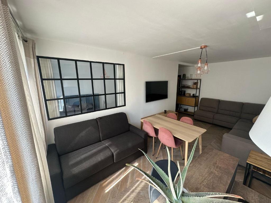 un salon avec un canapé et une table dans l'établissement Appartements Paris Expo Versailles, à Paris