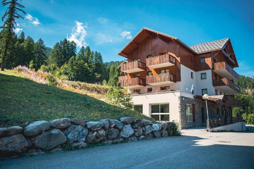 une maison sur une colline avec un mur de pierre dans l'établissement Les Gentianes by Actisource, à Puy-Saint-Vincent