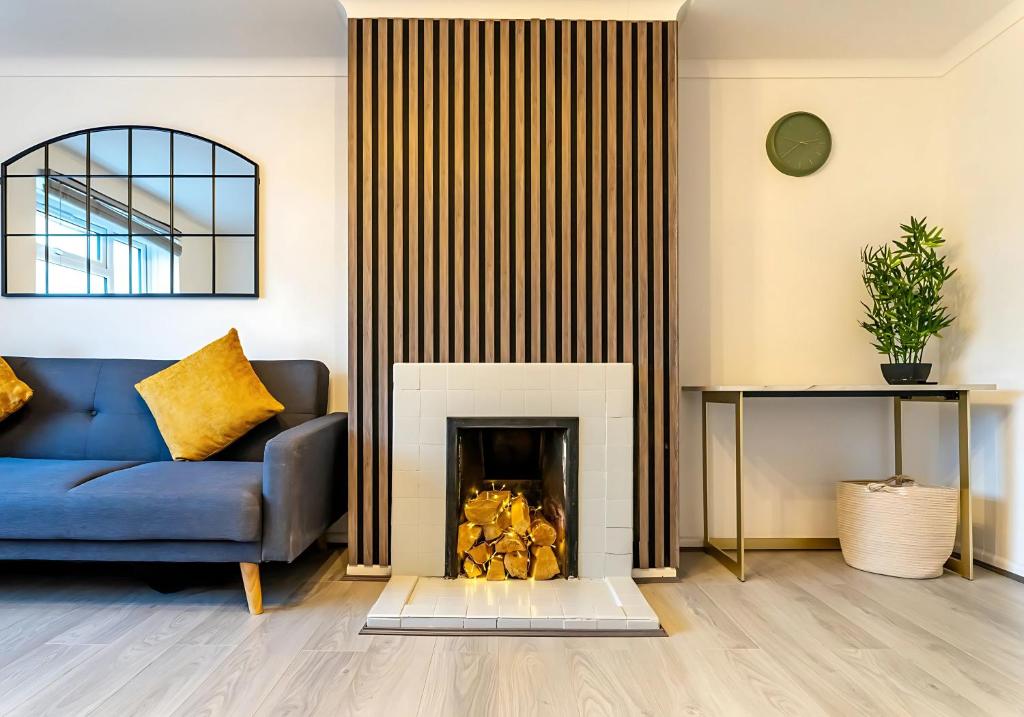 Long LawfordにあるDen Duplexの青いソファと暖炉のあるリビングルーム