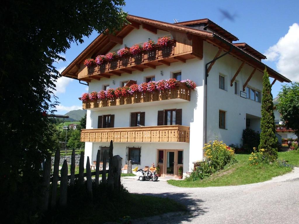 a large white building with flowers on the balcony at Rosenheim Appartement 2 in Maranza