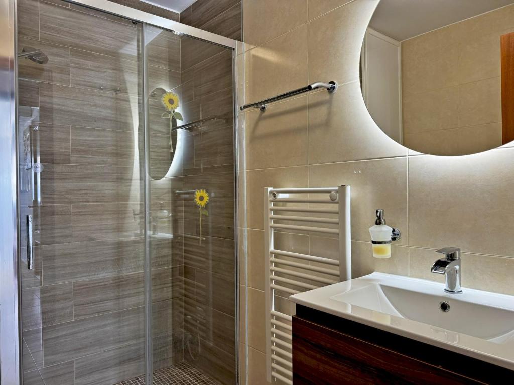 W łazience znajduje się prysznic, umywalka i lustro. w obiekcie Apartamento Esencia - Ole Solutions w mieście Arcos de la Frontera