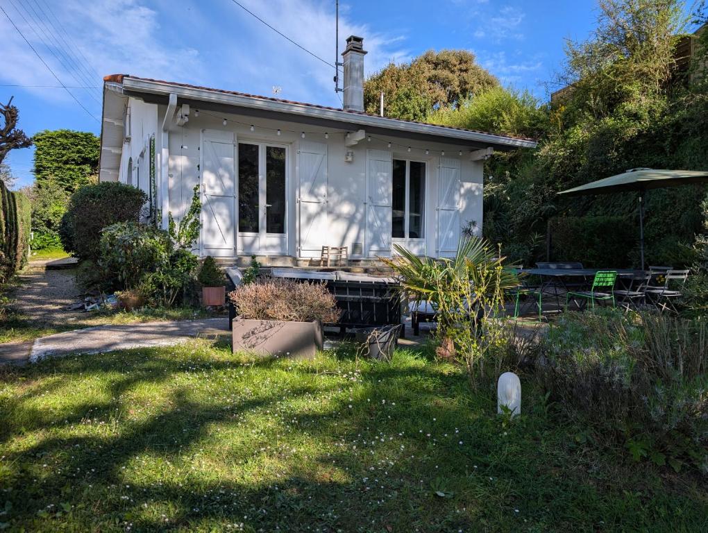 une maison blanche avec un chien dans la cour dans l'établissement Esprit vacances entre jardin & plage du Porteau, à Pornic