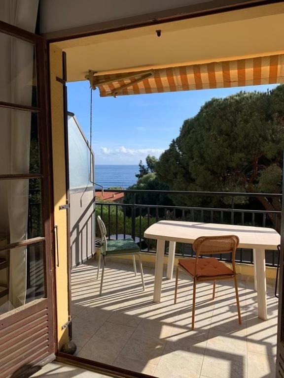 d'une table blanche et d'une chaise sur un balcon. dans l'établissement Coin de paradis aux Sanguinaires, à Ajaccio