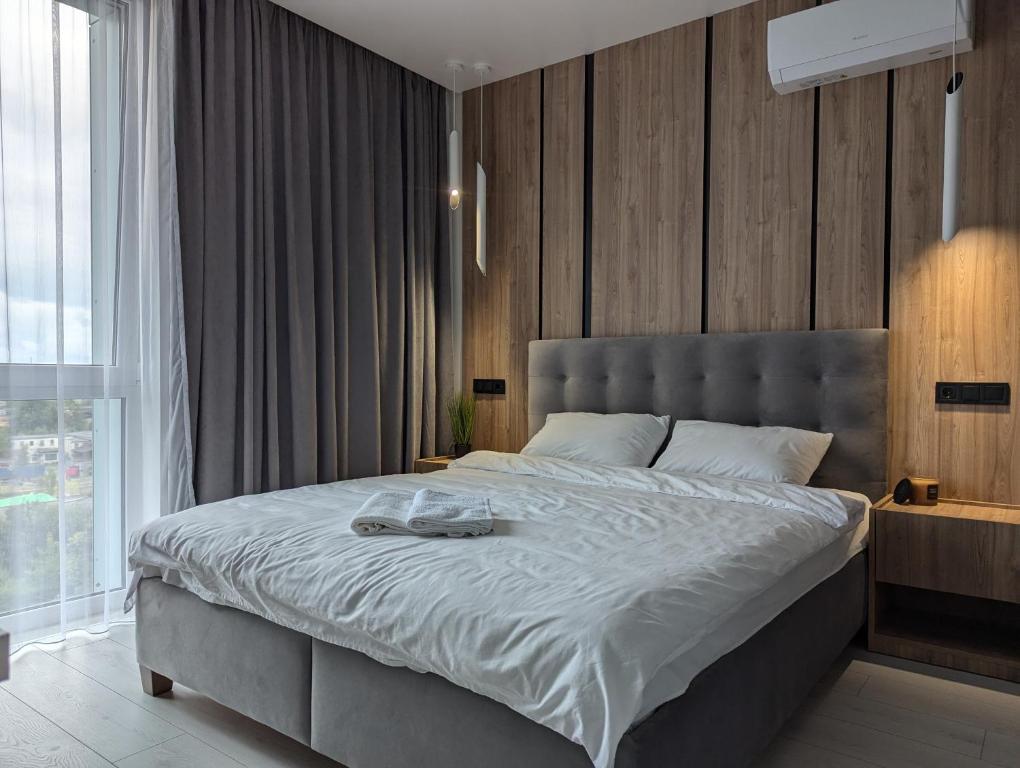 リヴィウにあるДизайнерські 2 кімнатні апартаменти Стрийськаの大きなベッドと大きな窓のある寝室