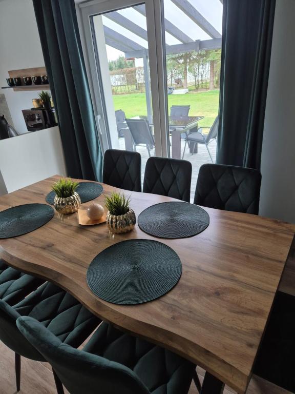 a wooden table with four mats on top of it at Apartamenty Gajewscy in Lipnica Górna