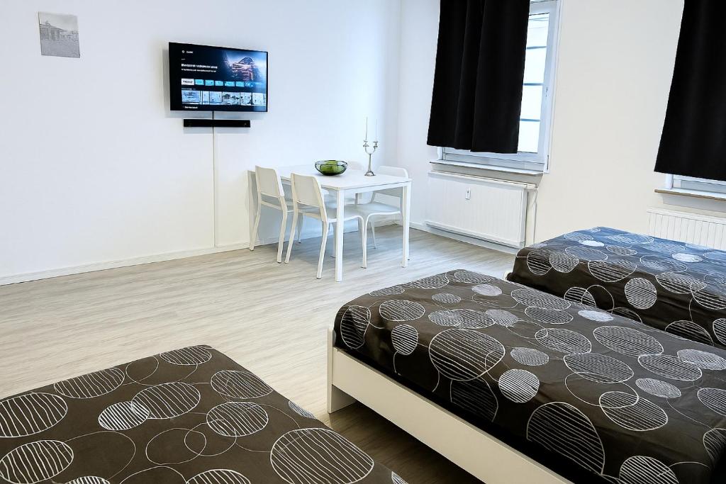 ゾーリンゲンにあるVAZ Apartments Birkenweiher für Monteure und Fachkräfte, WLAN,TV, Küche, 4-8 Personenのベッド2台、テーブル、テレビが備わる客室です。