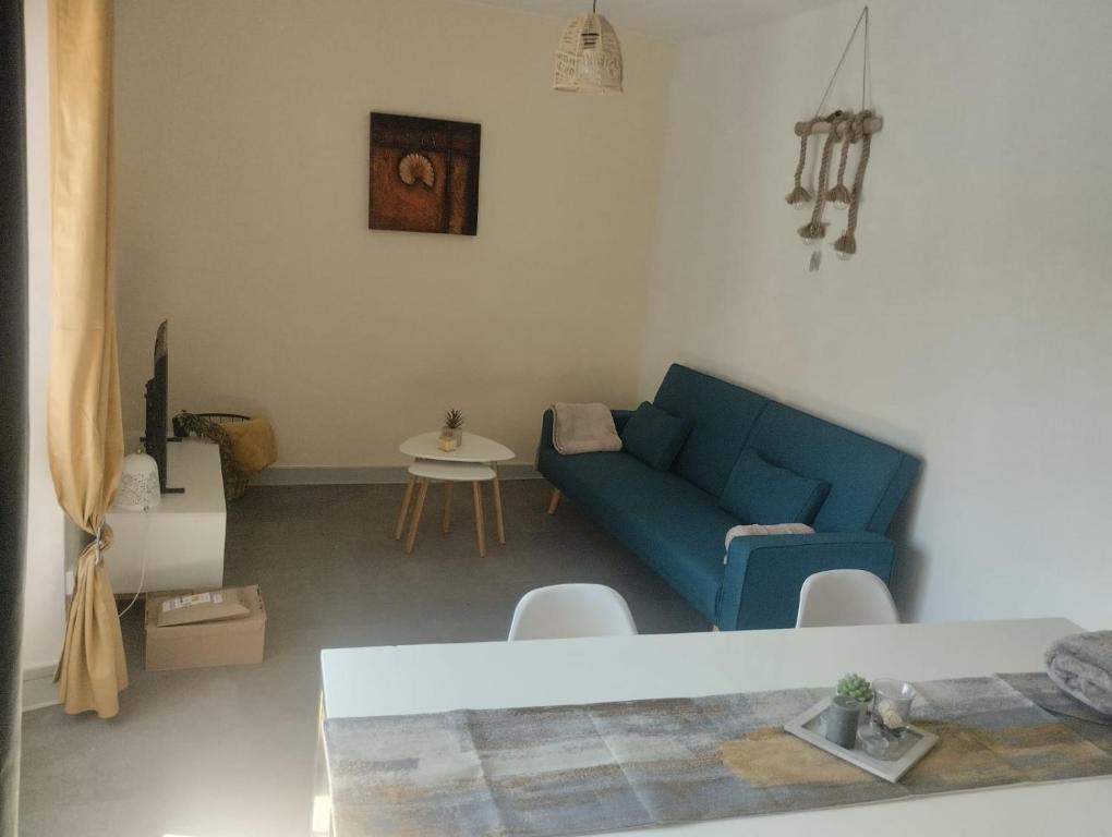 a living room with a blue couch and a table at Maison de ville centrale in Vierzon