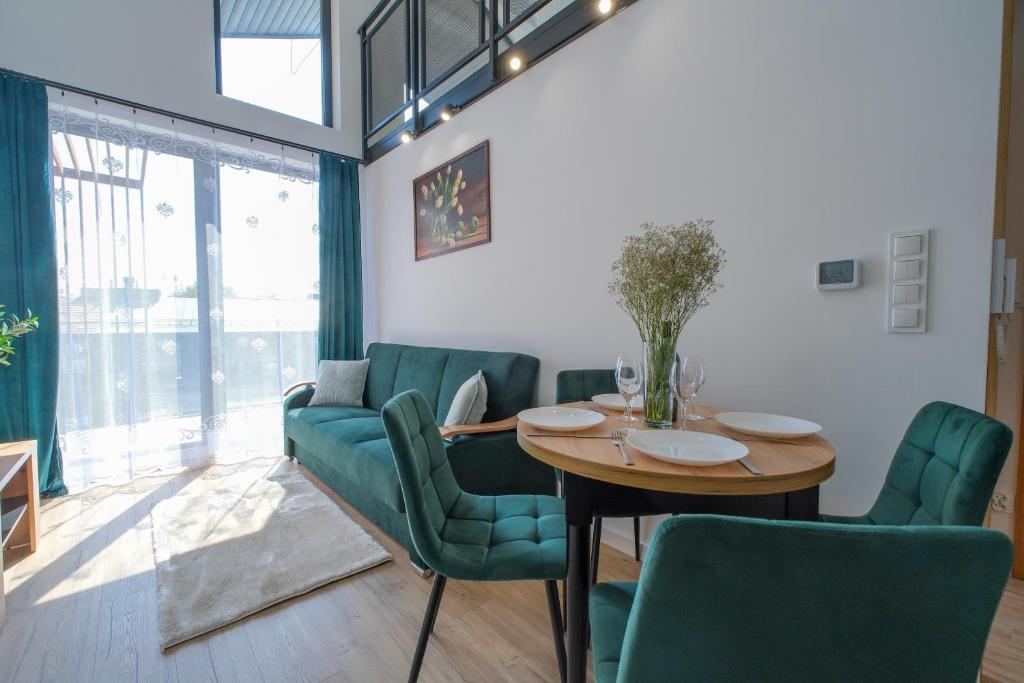 a dining room with a table and green chairs at Laguna Beskidów Resort - Apartament E59 in Zarzecze