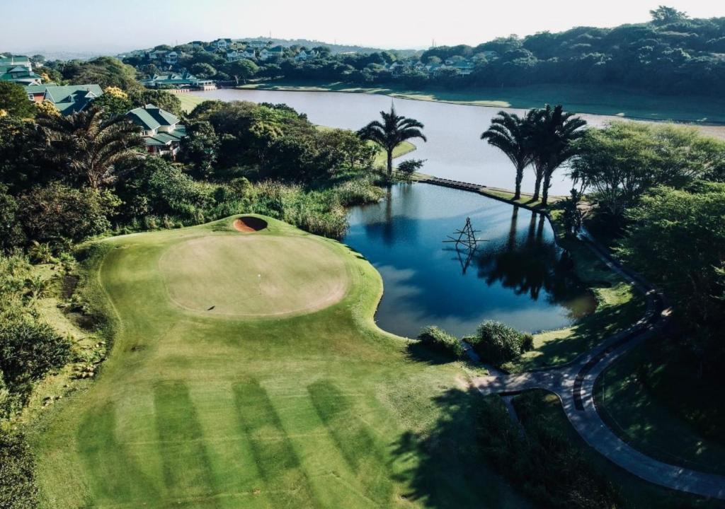an aerial view of a golf course with a lake at Cosy Urban Apartment in Durban