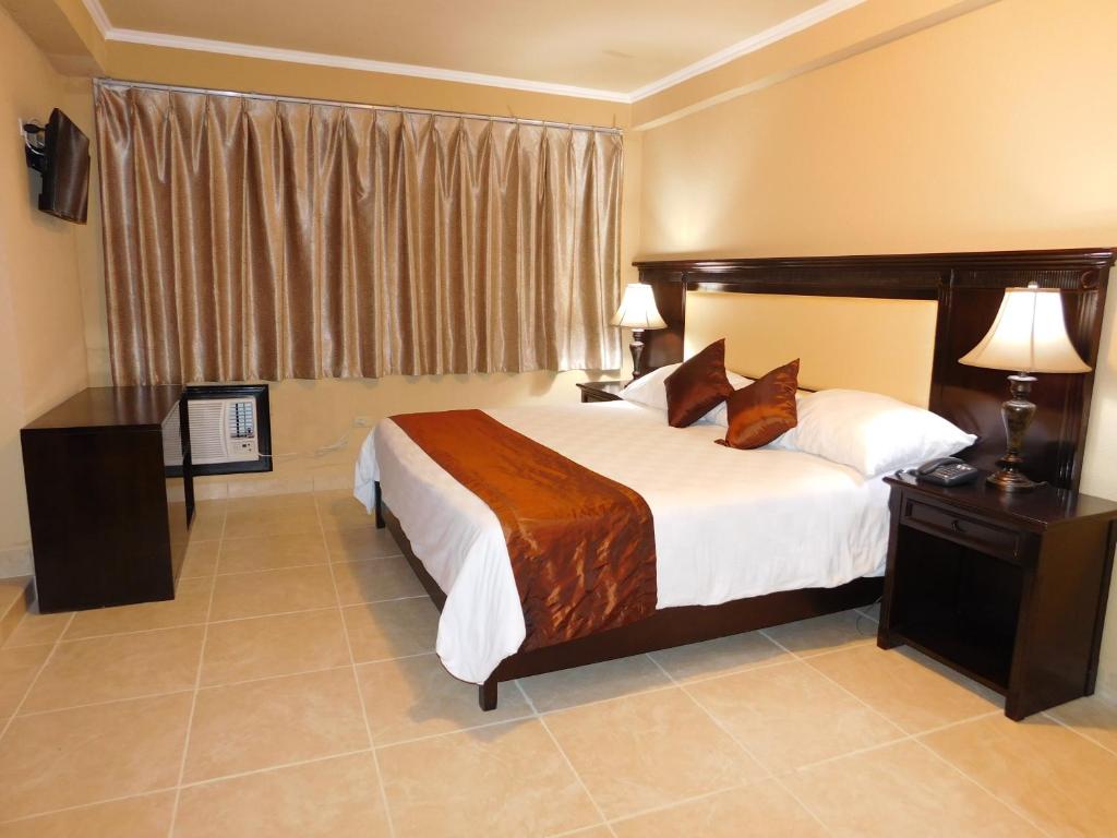 Habitación de hotel con cama grande y ventana en Hotel Gran Vía Panama, en David